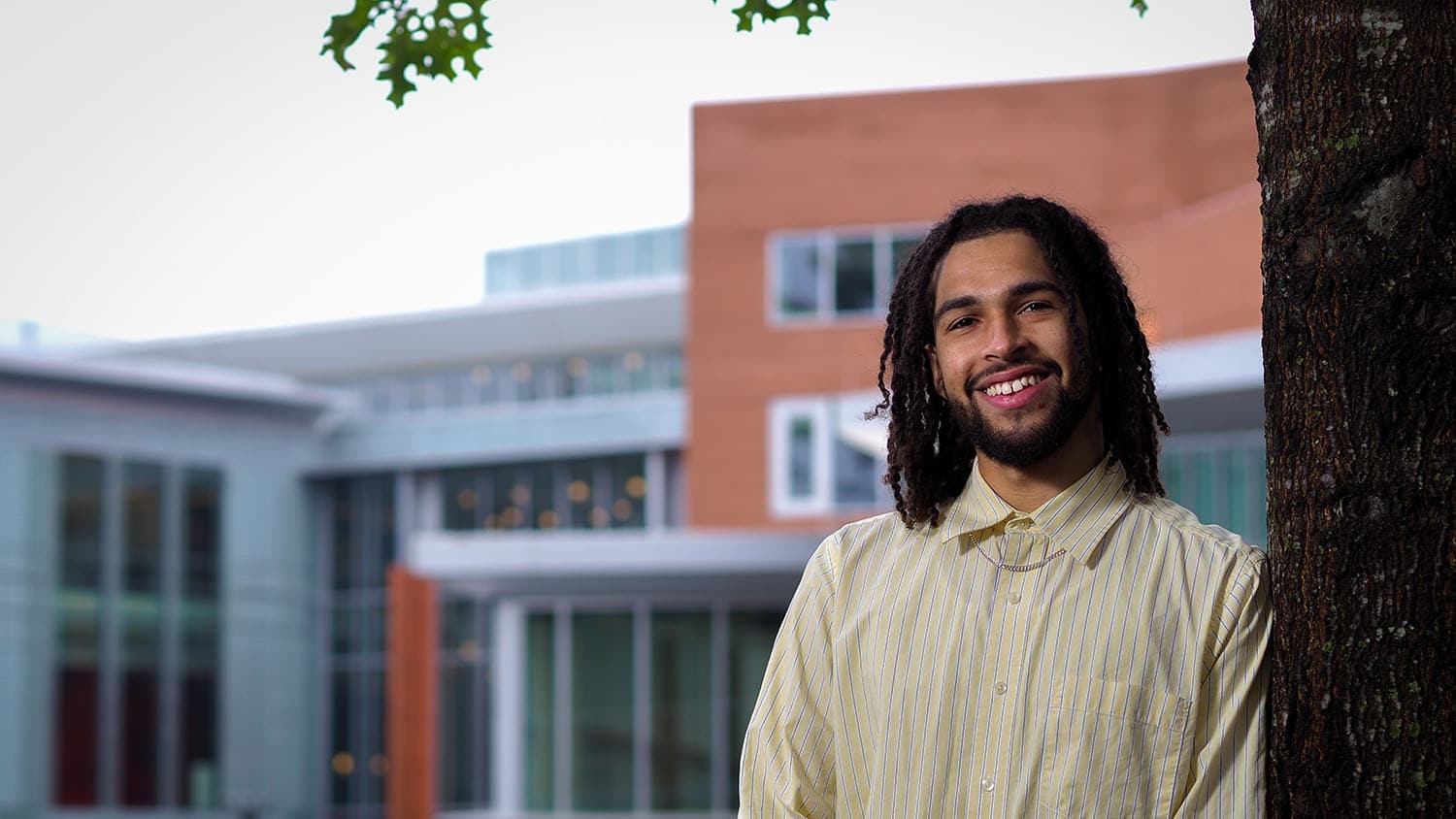 Gino Fernandes stands next to a tree with Talley Student Union in the background